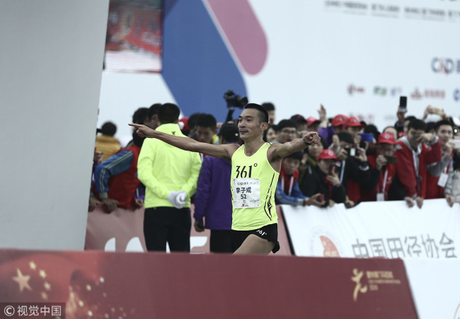 Chinese runner Li Zicheng crosses the finish line at 2019 Xiamen Marathon on January 6. [Photo: VCG] 
