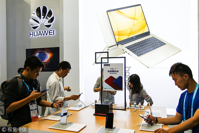 People try out Huawei products at a Huawei store in Shanghai on July 8, 2017. [File photo: VCG]