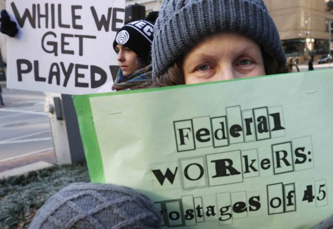 Esther Anastasia holds a sign during a protest rally with government workers and their supporters in Boston, Friday, Jan.11, 2019. [Photo: AP]
