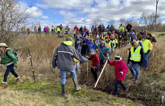 In this Oct. 23, 2018, file photo, volunteers cross a creek and barbed wire near Barron, Wis., on their way to a ground search for 13-year-old Jayme Closs who was discovered missing Oct. 15 after her parents were found fatally shot at their home. The Barron County Sheriff's Department said on its Facebook page that that the teenager Closs has been located Thursday, Jan. 10, 2019, and that a suspect was taken into custody. [File Photo: AP/Jeff Baenen]