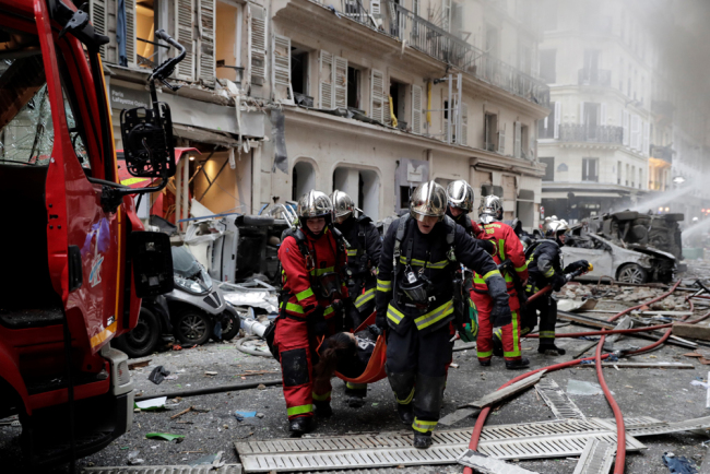 Firefighters evacuate an injured person after the explosion of a bakery on the corner of the streets Saint-Cecile and Rue de Trevise in central Paris on January 12, 2019. [Photo: AFP/Thomas Samson]