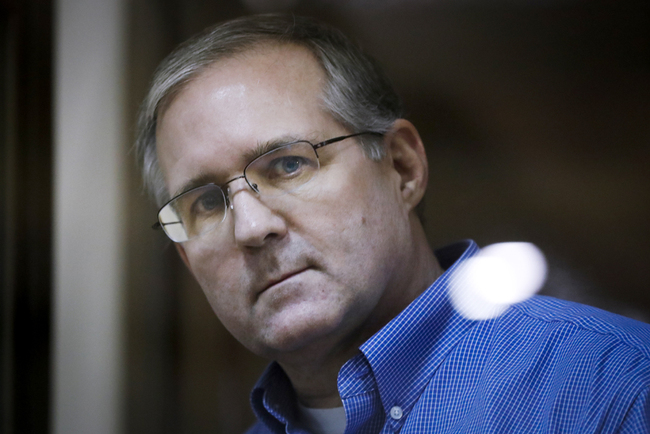 Paul Whelan, a former U.S. Marine, who was arrested in Moscow at the end of 2018 looks through a cage's glass in a court room in Moscow, Russia, Jan. 22, 2019. [Photo: AP/Pavel Golovkin]