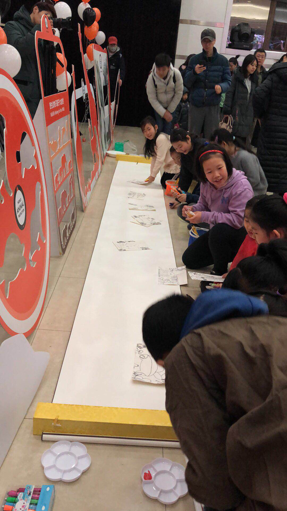 Children draw animals on a 10-meter-long scroll, alongside an exhibition held by Chinese artist Xu Qiping in Beijing on Sunday, Jan 20, 2019. [Photo: China Plus]