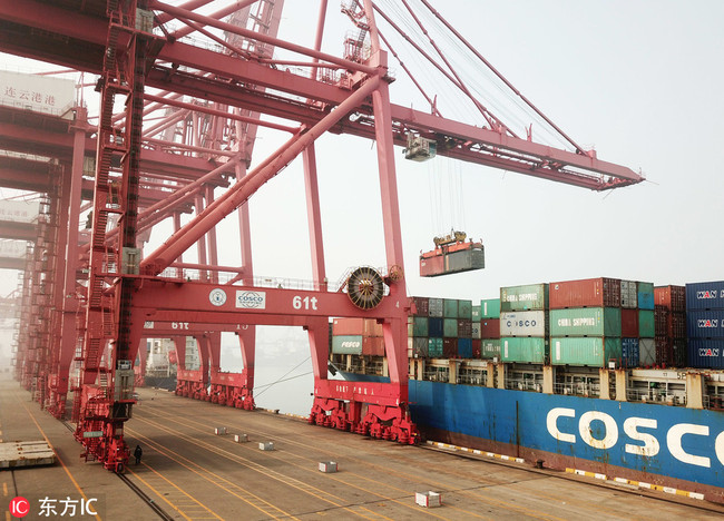 A cargo ship unloads goods at a container terminal of Lianyungang Port, Jiangsu province. [File Photo: IC]