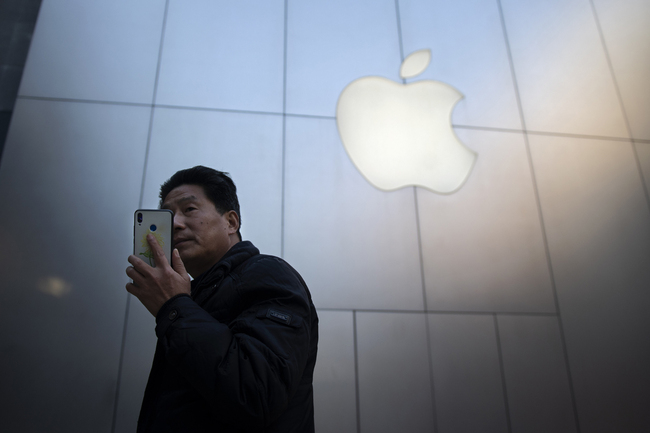 A man uses a smartphone outside an Apple store in Beijing on January 4, 2019. [Photo: AFP]