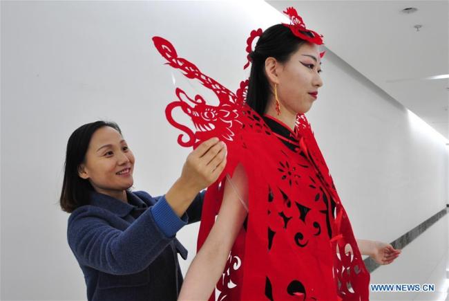 “剪纸”服饰迎新春 Craftswoman makes papercutting works of cheongsam to greet Spring Festival
