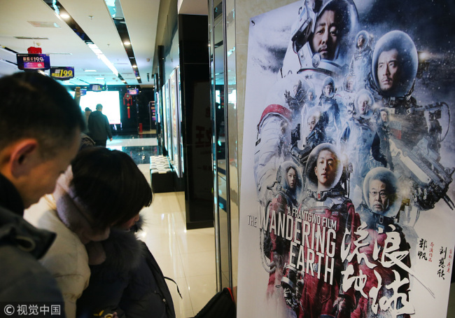 Moviegoers watch a poster for "The Wandering Earth" at a cinema in Nantong, Jiangsu Province on February 10, 2019. [Photo: VCG]