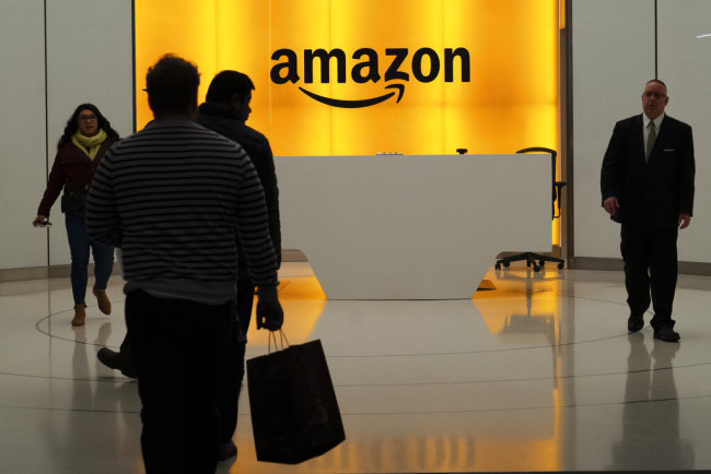 People walk into the lobby for Amazon offices Thursday, Feb. 14, 2019, in New York. Amazon will not build a new headquarters in New York City, a stunning reversal to an ambitious plan that would have brought an estimated 25,000 jobs to the city. [Photo: AP]