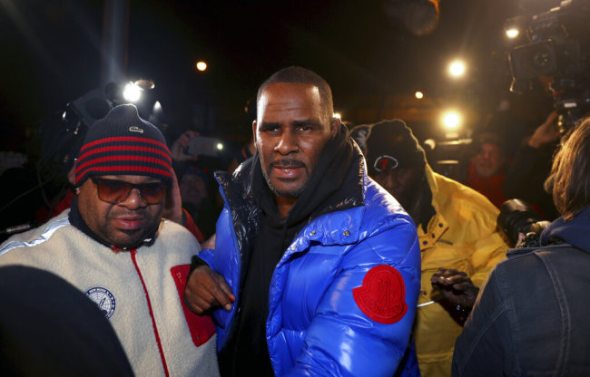 R. Kelly turns himself in at 1st District police headquarters in Chicago on Friday night, Feb. 22, 2019. R&B star R. Kelly arrived Friday night at a Chicago police precinct, hours after authorities announced multiple charges of aggravated sexual abuse involving four victims, including at least three between the ages of 13 and 17. [Photo: Chicago Tribune via AP/Chris Sweda]
