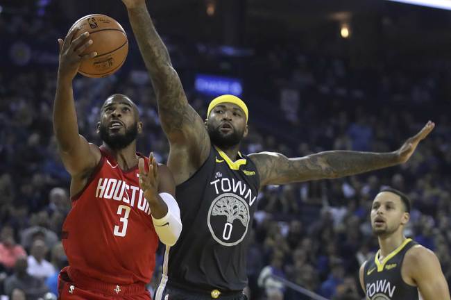 Houston Rockets' Chris Paul, left, lays up a shot past Golden State Warriors' DeMarcus Cousins, center, in the first half of an NBA basketball game Saturday, Feb. 23, 2019, in Oakland, Calif. [Photo: AP Photo/Ben Margot]