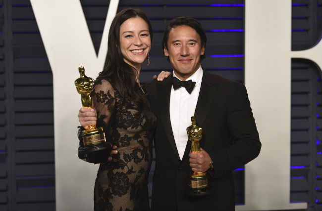 Elizabeth Chai Vasarhelyi, left, and Jimmy Chin, winners of the award for best documentary feature for "Free Solo", arrives at the Vanity Fair Oscar Party on Sunday, Feb. 24, 2019, in Beverly Hills, Calif. [Photo: AP/Evan Agostini/Invision]