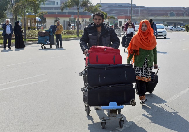 Stranded passengers wait for transport outside Allama Iqbal Airport after it was closed for civilians operations amid tension along the border with India, in Lahore, Pakistan, Wednesday, Feb. 27, 2019. Pakistan's military said Wednesday it shot down two Indian warplanes in the disputed region of Kashmir and captured two pilots, raising tensions between the nuclear-armed rivals to a level unseen in 20 years.[Photo:IC]