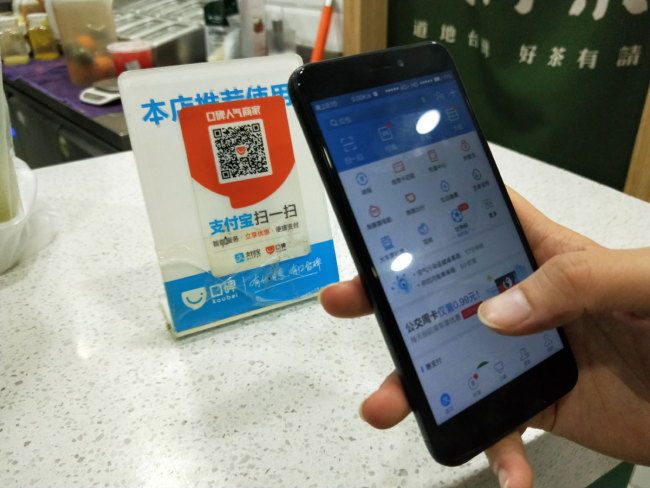 A Chinese mobile phone user scans a QR code via mobile payment service Alipay of Alibaba Group on his smartphone in Ji'nan city, east China's Shandong province, 7 July 2018. [Photo: IC]