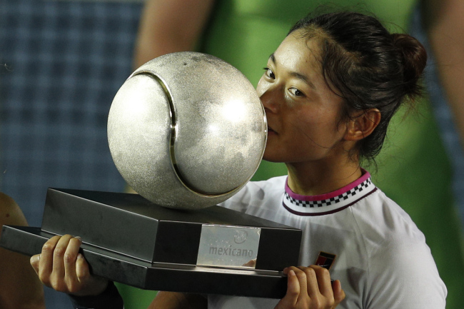 China's Yafan Wang kisses her trophy as she poses for photographers after winning her Mexican Tennis Open final match against Sofia Kenin of the U.S., in Acapulco, Mexico, Saturday, March 2, 2019. [Photo: AP]