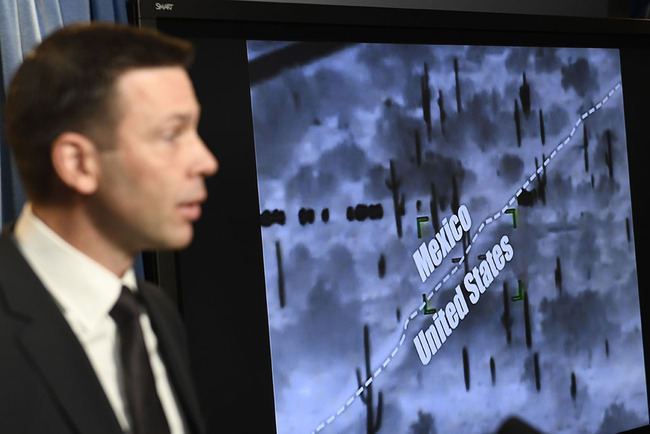 With surveillance footage in the background, U.S. Customs and Border Patrol Commissioner Kevin McAleenan speaks during a news conference in Washington, Tuesday, March 5, 2019. [Photo: AP]