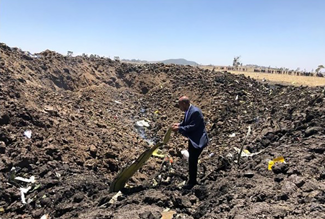 This handout photograph released from the Twitter account of Ethiopian Airlines on March 10, 2019, shows a man inspecting what is believed to be wreckage at the crash site of an Ethiopia Airlines aircraft near Bishoftu, a town some 60 kilometres southeast of Addis Ababa, Ethiopia. [Photo: AFP]