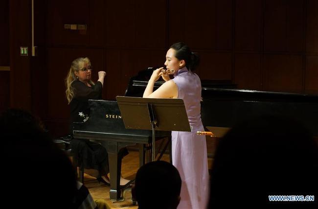 Visiting Chinese professor Yuxiao Chen (R) performs at a concert at Binghamton University in New York, the United States, on March 7, 2019. [Photo: Xinhua]