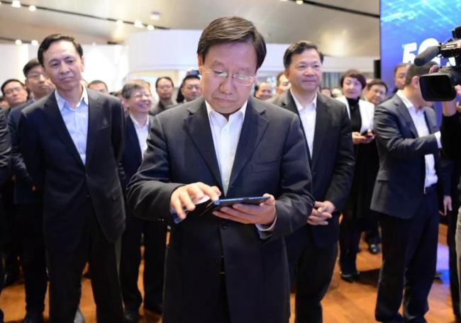 Wang Xiaohui (center), the administrative vice minister of the Publicity Department of the Communist Party of China Central Committee, operates a 4K video program using a Huawei 5G foldable phone in Beijing on Thursday, February 28, 2019. [Photo: China Plus]