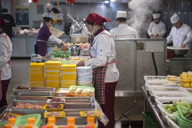 Staff at a restaurant at Zhejiang Gongshang University prepare dishes for students on Wednesday, March 13, 2019. [Photo: IC]