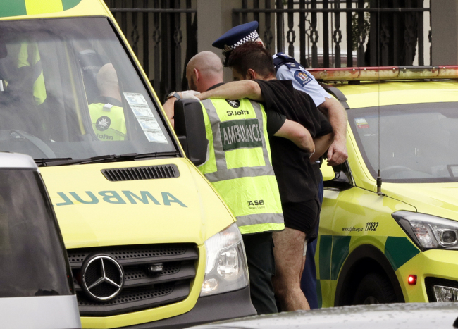 Police and ambulance staff help a wounded man from outside a mosque in central Christchurch, New Zealand, Friday, March 15, 2019. [Photo: AP/Mark Baker]