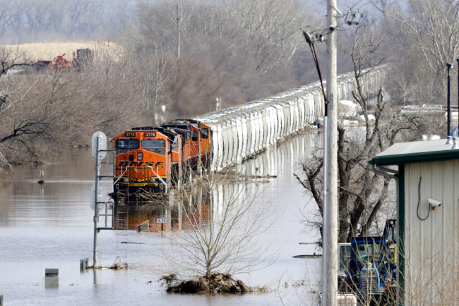 A BNSF train sits in flood waters from the Platte River, in Plattsmouth, Neb., Sunday, March 17, 2019. Hundreds of people remained out of their homes in Nebraska, but rivers there were starting to recede. The National Weather Service said the Elkhorn River remained at major flood stage but was dropping. [Photo: AP]