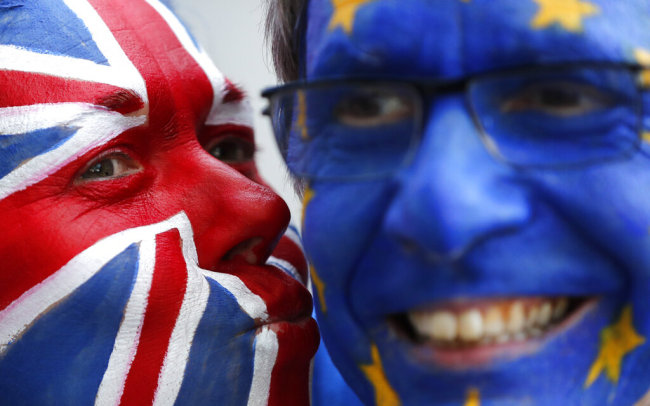 Activists poses with their faces painted in the EU and Union Flag colors during an anti-Brexit campaign stunt outside EU headquarters during an EU summit in Brussels, Thursday, March 21, 2019. British Prime Minister Theresa May is trying to persuade European Union leaders to delay Brexit by up to three months, just eight days before Britain is scheduled to leave the bloc. [Photo: AP] 