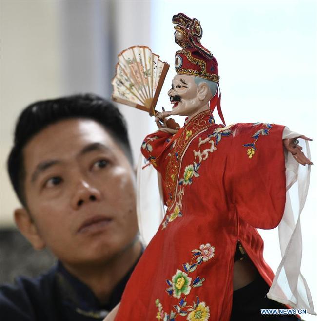 Chen Lihui from Zhangzhou city in southeast China's Fujian province performs Fujian Puppetry at Paint Branch Elementary School in the Prince George's County, Maryland, the United States, March 20, 2019. [Photo: Xinhua]