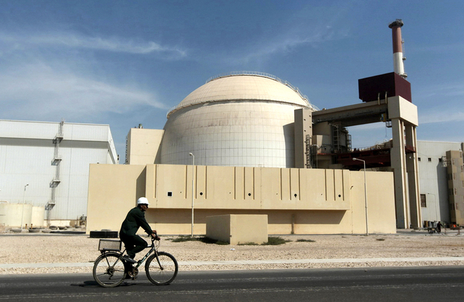 A worker rides a bicycle in front of the reactor building of the Bushehr nuclear power plant, just outside the southern city of Bushehr. [File photo: AP/Mehr News Agency/Majid Asgaripour]