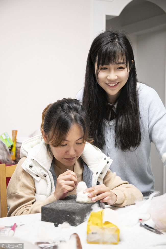 Cici teaches a trainee(徒弟 túdì) to make a pet model at her home in Guangzhou, Guangdong province on March 24, 2019. [Photo/VCG]