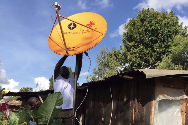 A technician trained by StarTimes helps a family install a digital receiver for satellite television. [Photo provided to China Plus]