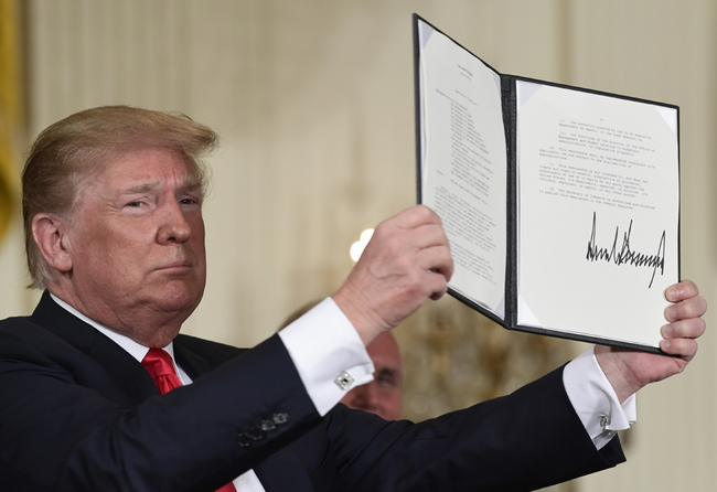 In this June 18, 2018 file photo, President Donald Trump holds up the space policy directive that he signed during a National Space Council meeting in the East Room of the White House in Washington. [File Photo: AP]