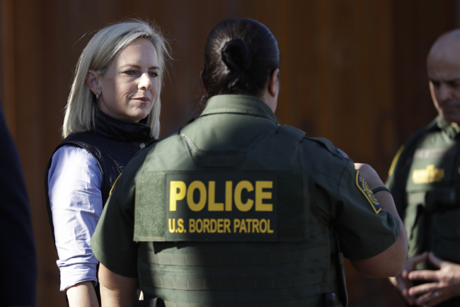 In this Friday, Oct. 26, 2018, file photo, U.S. Department of Homeland Security Secretary Kirstjen Nielsen, left, speaks with Border Patrol agents near a newly fortified border wall structure in Calexico, Calif. [File Photo: AP]