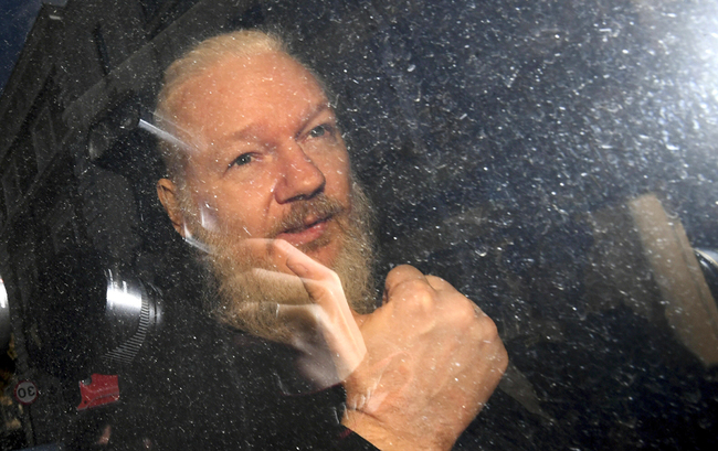 Julian Assange gestures as he arrives at Westminster Magistrates' Court in London, after the WikiLeaks founder was arrested by officers from the Metropolitan Police and taken into custody on April 11, 2019. [Photo: PA via AP/Victoria Jones]