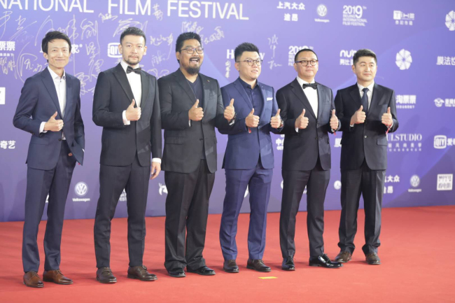 Director Guo Fan (L2) of "The Wandering Earth" poses on red carpet with crew at the closing ceremony for the 9th Beijing International Film Festival, on April 20, 2019, in Beijing. [Photo: CGTN]