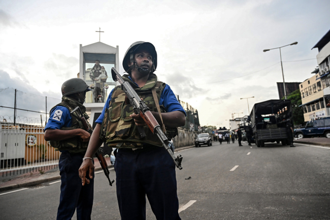 Sri Lankan soldiers stand guard near a car explosion after the police tried to defuse a bomb near St. Anthony's Shrine in Colombo on April 22, 2019, a day after the series of bomb blasts targeting churches and luxury hotels in Sri Lanka. [Photo: AFP/Jewel SAMAD]
