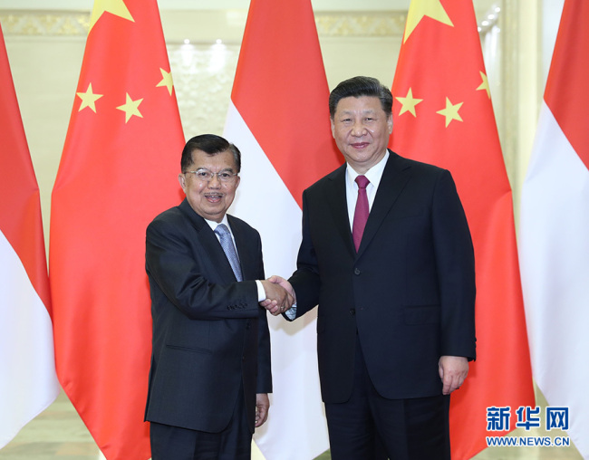 Chinese President Xi Jinping (R) shakes hands with Indonesian Vice President Jusuf Kalla on Thursday, April 25, at the Great Hall of the People, in Beijing. [Photo: Xinhua]