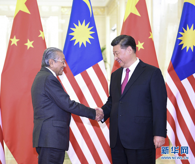 Chinese President Xi Jinping (R) shakes hands with Malaysian Prime Minister Mahathir Mohamad on Thursday, April 25, at the Great Hall of the People, in Beijing. [Photo: Xinhua]