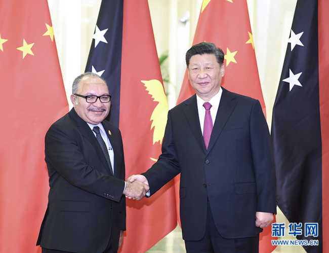 Chinese President Xi Jinping (R) shakes hands with Papua New Guinea (PNG) Prime Minister Peter O'Neill on Thursday, April 25, at the Great Hall of the People, in Beijing. [Photo: Xinhua]
