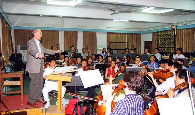 The photo was taken in May 1999. Li Huanzhi was invited by the orchestra to conduct the Spring Festival Overture during the rehearsal. It was the last time Li Huanzhi raised his music baton. [Photo Courtesy of Li Dakang]