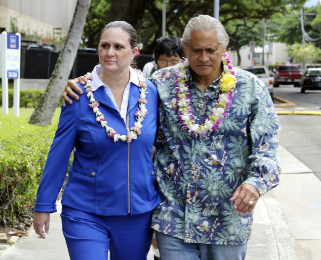FILE - In this Oct. 20, 2017 file photo, former Honolulu Police Chief Louis Kealoha and his wife Katherine Keahola leave federal court in Honolulu. Kealoha was Honolulu's Rolex-wearing police chief and his wife Katherine was the Maserati-driving prosecutor in charge of a unit targeting career criminals. Prosecutors say the couple funded a lavish lifestyle by defrauding banks, relatives and children. They're heading to trial in May 2019 on charges they orchestrated the framing of a relative for a mailbox theft who threatened to expose their fraud. [Photo: AP/Caleb Jones]