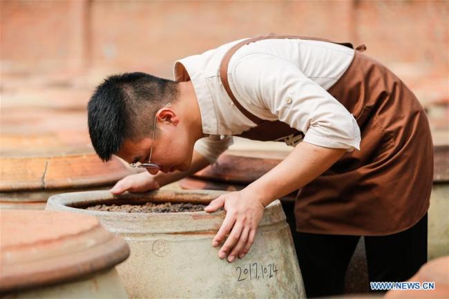 Wu Huaqing examines(检查 jiǎnchá) the fermentation(发酵 fājiào) of soy bean(黄豆 huángdòu) at his company in Quanzhou, southeast China's Fujian Province, April 29, 2019. [Photo: Xinhua]