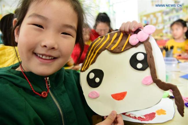 A kid(孩子 háizi) demonstrates a handmade smiley card(卡片 kǎpiàn) to greet the upcoming World Smile Day at a kindergarten in Zhenjiang, east China's Jiangsu Province, May 7, 2019.[Photo: Xinhua]