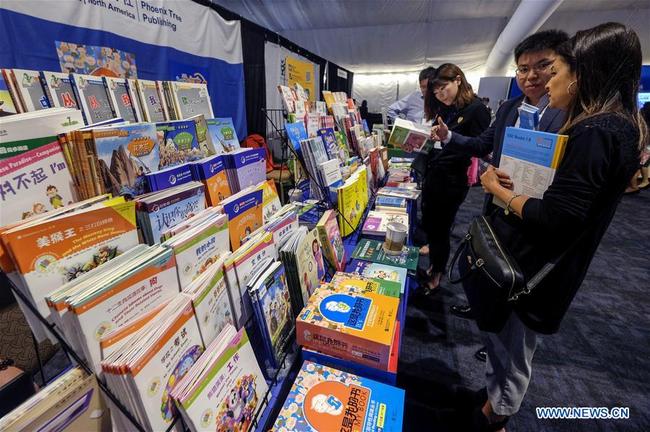 Attendees browse books during an education exhibition at the 12th National Chinese Language Conference (NCLC) in San Diego, the United States, on May 10, 2019. [Photo: Xinhua/Zhao Hanrong]