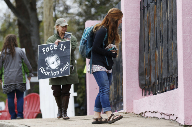 In this March 20, 2018, file photo, anti-abortion sidewalk counselors call out to a woman entering the Jackson Women's Health Organization's clinic, the only facility in the state that performs abortions, in Jackson, Miss. A new Mississippi law could make it nearly impossible for most pregnant women to get an abortion there if it survives a court challenge. [File Photo: AP]