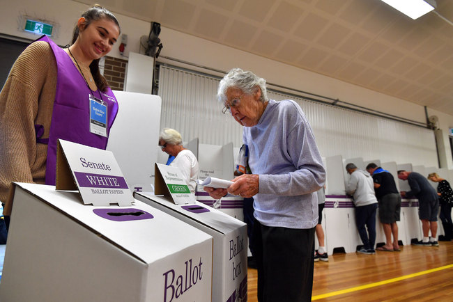 A voter drops her ballot paper into the ballot box at the Lilly Pilly polling booth during the Australia's general election in Sydney on May 18, 2019.[Photo: AFP/Saeed KHAN ]