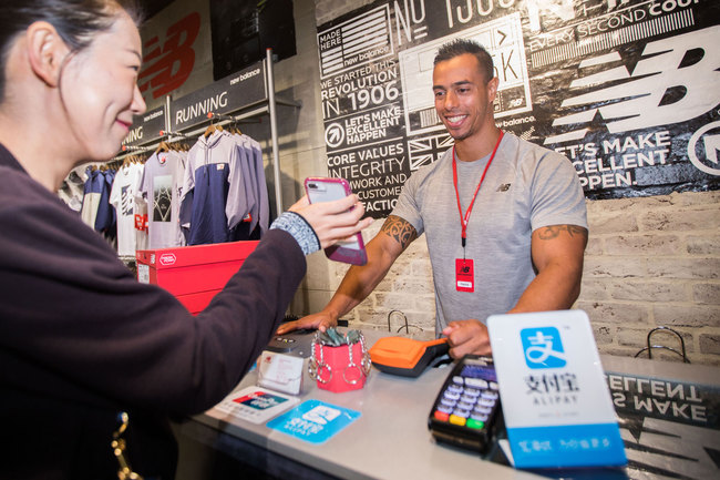 A customer uses her smartphone to pay using Alipay at a store in Sydney, Australia on April 26, 2018. [Photo: IC]