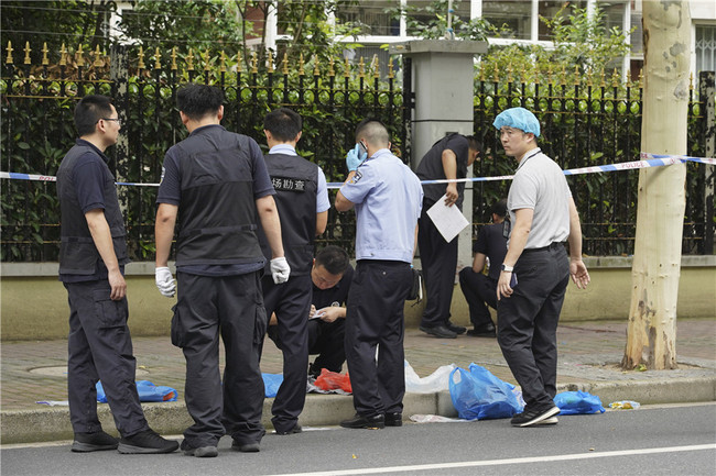 Police examine the site of a knife attack that occurred in downtown Shanghai leaving two boys dead and another boy and a parent wounded on June 28, 2018. [Photo: China Daily]