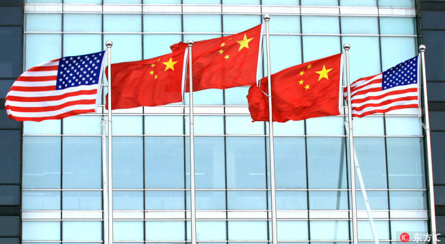 National flags of China and the United States fly in front of a new international finance center in downtown Beijing, November 23, 2011. [File Photo: IC]