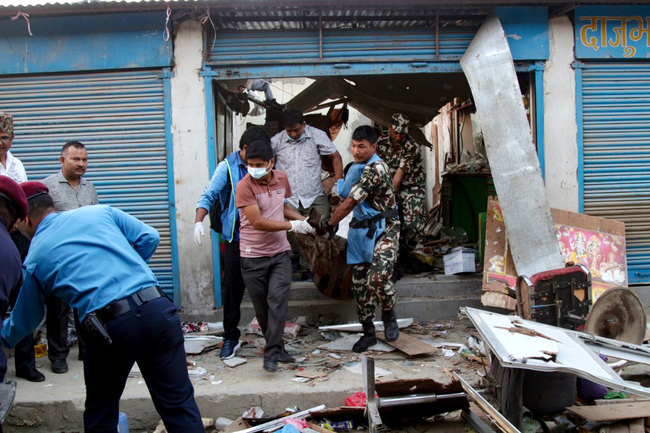 Nepali security personnel carry the body of a victim killed in a blast in Kathmandu on May 26, 2019. [Photo: AFP]