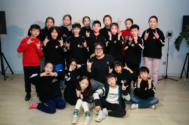 There are about fifty members of Stone and Children Band. Here are some members taking picture with Shi Dongying. [Photo: courtesy of Shi Dongying, music producer of Stone and Children Band]
